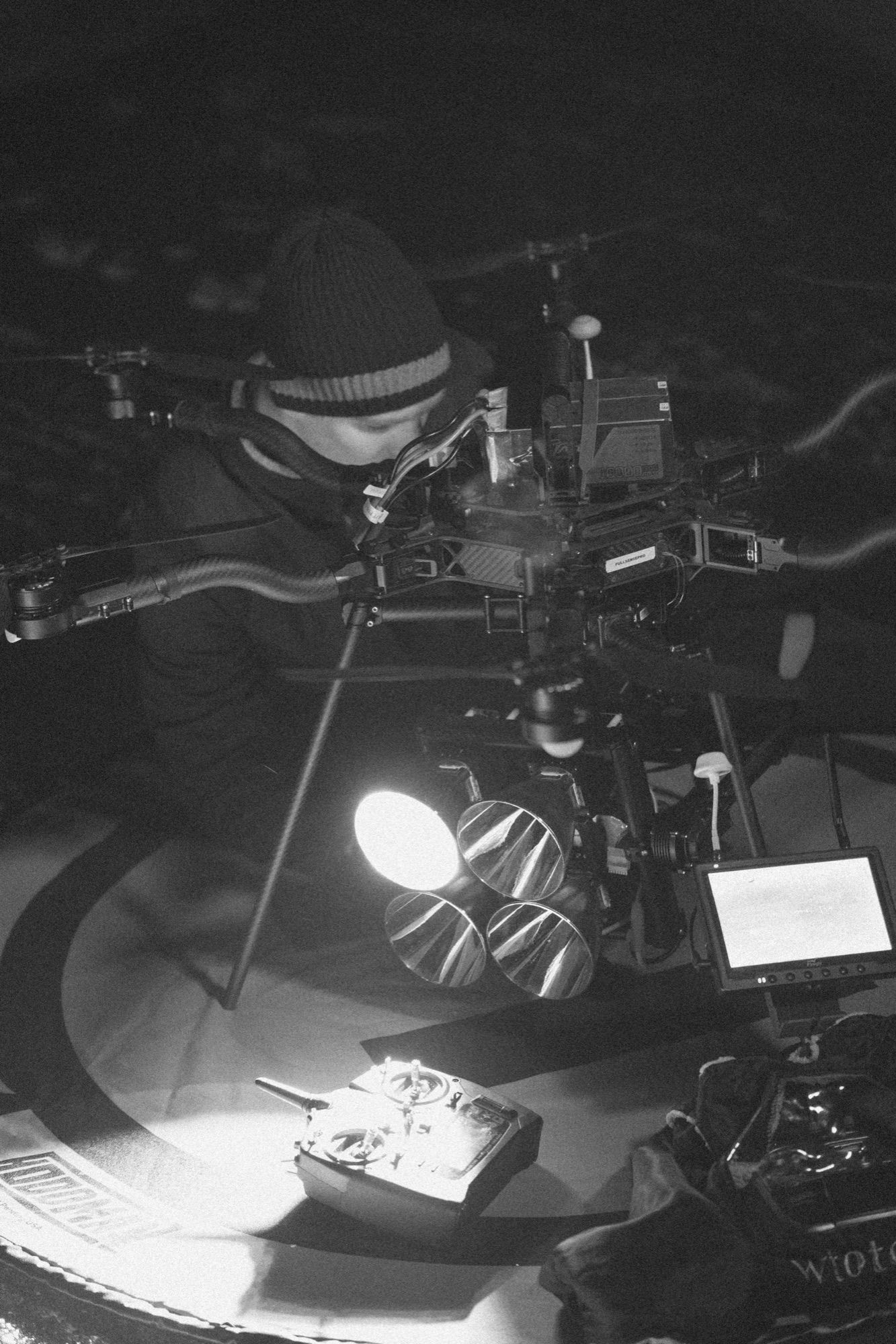 Finn Johnson working over a heavy-lift cinema drone under a single spotlight.
